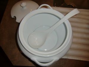 Stylish white porcelain soup tureen with ladle and lid